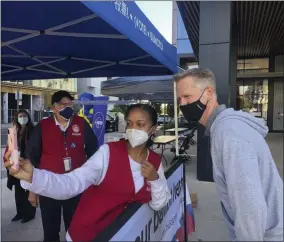  ?? JANIE MCCAULEY - THE ASSOCIATED PRESS ?? Golden State Warriors coach Steve Kerr poses for a selfie with voting worker Jujuana Williams of Oakland on Saturday, Oct. 31, in San Francisco.