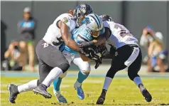  ?? NELL REDMOND/AP ?? Carolina Panthers' Christian McCaffrey is tackled by Baltimore Ravens' C.J. Mosley, left, and Tony Jefferson last month. With today's volcanic offenses, can't-hit-'em-too-hard rules and befuddled officials, linebacker­s aren't snarling 250-pound thumpers starring in running backs' nightmares anymore.