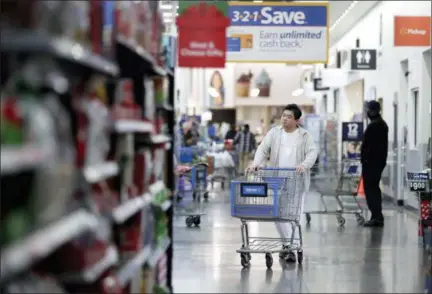  ?? THE ASSOCIATED PRESS ?? A man pushes a cart while shopping at a Walmart store in North Bergen, N.J.