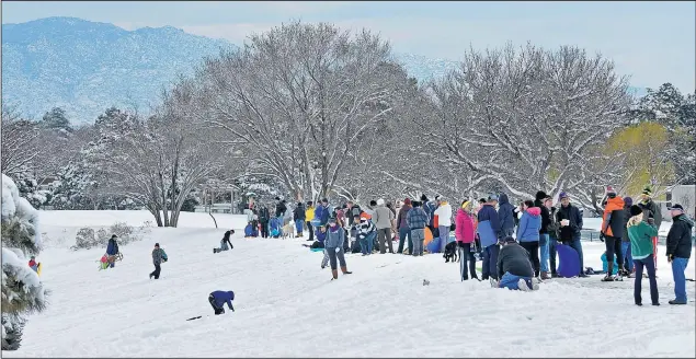  ?? JIM THOMPSON/JOURNAL ?? Sledders and others enjoy the snow at Arroyo del Oso golf course in Northeast Albuquerqu­e on Saturday.