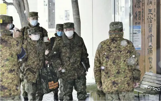  ??  ?? The Yomiuri Shimbun Ground Self-Defense Force nurses enter Keiyukai Yoshida Hospital at around 8 a.m. on Wednesday in Asahikawa, Hokkaido.