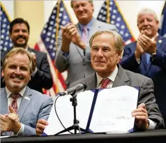  ?? LM OTERO/ASSOCIATED PRESS ?? Texas Gov. Greg Abbott shows off Senate Bill 1, also known as the election integrity bill, after he signed it Tuesday into law in Tyler, Texas. The sweeping law has already drawn lawsuits against it.