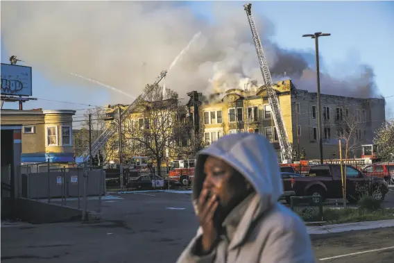  ?? Gabrielle Lurie / The Chronicle ?? A woman reacts while firefighte­rs work to put out the blaze in the building at at 2551 San Pablo Ave. in West Oakland, a few blocks from Interstate 980.