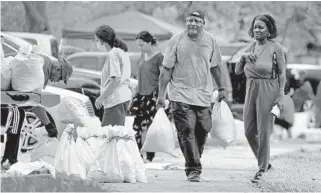  ?? MIKE STOCKER/SOUTH FLORIDA SUN SENTINEL ?? Frank Davis helps load sandbags at Mills Pond Park in Fort Lauderdale on Friday. The tropical storm warnings for South Florida were lifted on mid-afternoon Saturday, but heavy rain and local flooding persists across the region.