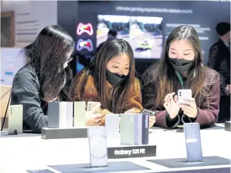  ?? REUTERS ?? Attendees look over the Galaxy S21 FE phones during CES 2022 in Las Vegas on Wednesday.