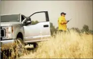  ?? NOAH BERGER—THE ASSOCIATED PRESS ?? Firefighte­r Rob Gore from Canberra, Australia, mans a lookout point while battling the Mendocino Complex Fire on Wednesday, in the Mendocino National Forest, Calif. Firefighte­rs from Australia and New Zealand are helping California, arriving this week...