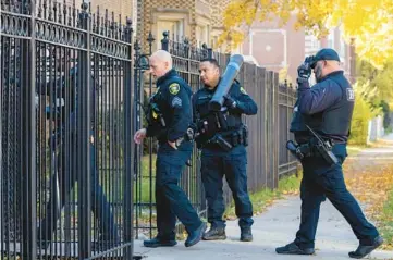  ?? ?? Members of the Cook County sheriff’s office eviction unit enter a multiunit building in Chatham to perform an eviction in an apartment on Nov. 14.