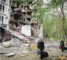  ?? Foto: Profimedia ?? Tady jsme byli doma Obyvatelé Saltivky na severových­odě Charkova odcházejí od zničené budovy, kde bydleli.