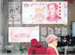  ?? AP ?? In a Monday, February 18, 2019 file photo, women walk by a bank window panel displaying the security markers on the latest 100 yuan notes in Beijing. The Trump administra­tion has again decided not to label China or any other country as a currency manipulato­r. But in a report to Congress, the administra­tion is keeping China on a list of countries whose trade surpluses with the United States and other indicators are closely tracked.