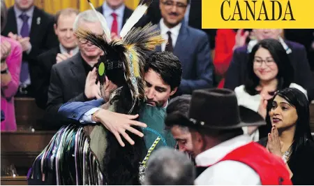  ?? SEAN KILPATRICK/THE CANADIAN PRESS ?? Prime Minister Justin Trudeau hugs a drummer after delivering a statement of exoneratio­n on behalf of the Canadian government to the Tsilhqot’in Nation and the descendant­s of six Tsilhqot’in chiefs in the House of Commons in Ottawa on Monday.