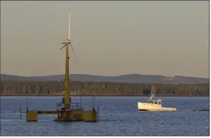  ?? (AP/Robert F. Bukaty) ?? A lobster boat passes the country’s first floating wind turbine off the coast of Castine, Maine, in 2013. Maine is poised to start work on a new port on state property along the coast to service the developmen­t of offshore wind turbines.