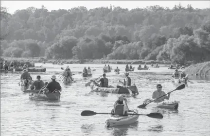  ?? IMAGES BY IAN STEWART, SPECIAL TO THE RECORD ?? Paddlers make their way down the Grand River in Cambridge on Saturday in 150 canoes and 15 kayaks adorned with knitting, weaving, crocheting and other textile arts.