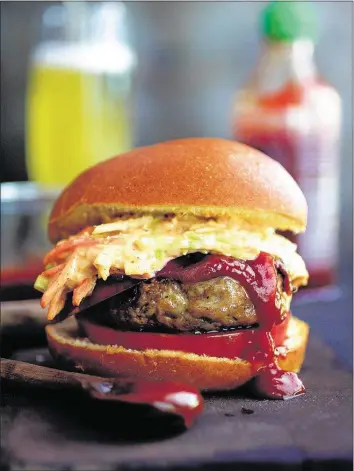  ?? PHOTO BY CAROL BORCHARDT ?? Hoisin ketchup and sriracha slaw give grilled pork burgers an Asian kick. They can also be made with ground turkey or beef.