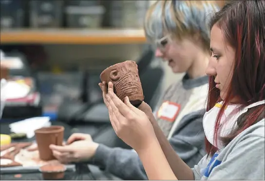  ?? PHOTOS BY JENNY SPARKS — LOVELAND REPORTER-HERALD ?? Lucile Erwin Middle School student Jadyn Forgey, 14, far right, and Bill Reed Middle School student Alex Simpson, right, make mugs out of clay Wednesday during a Shadows in the Arts event at the Beet Education Center in Loveland.