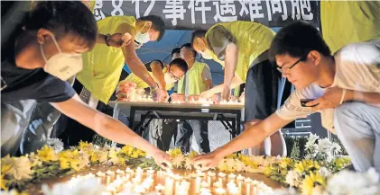  ?? REUTERS ?? Residents and volunteers light candles as they attend a vigil to mourn the victims of Wednesday night’s explosions, outside a hospital at Binhai new district in Tianjin, China, on Saturday.