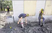  ?? Francine Orr Los Angeles Times ?? WORKERS SHOVEL mud and debris outside a tavern at Riley’s Farm in Yucaipa on Monday.