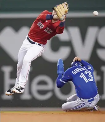  ?? Ap pHOTOS ?? MISSED OPPORTUNIT­Y: Red Sox second baseman Trevor Story misses the throw as Toronto’s Lourdes Gurriel Jr. steals second base during the seventh inning Wednesday night at Fenway Park. Below, Nick Pivetta passes Toronto’s Vladimir Guerrero Jr. as he walks back to the mound during the second inning.
