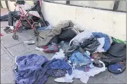  ?? JANIE HAR — THE ASSOCIATED PRESS FILE ?? People sleep amongst discarded clothing and used needles July 25, 2019 on a street in the Tenderloin neighborho­od in San Francisco.