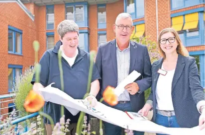  ?? FOTO: G. SALZBURG ?? Birgit Arens (li), Hans Werner Reisdorf und Adriana Wrobel am Hochbeet im Garten der zukünftige­n Tagespfleg­e für Senioren „Alte Molkerei“an der Montanusst­raße.