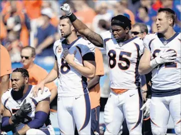  ?? Adrian Kraus Associated Press ?? DENVER BRONCOS players, including Virgil Green, with fist raised, demonstrat­e solidarity during the playing of the national anthem before their game Sunday against the Buffalo Bills in Orchard Park, N.Y.