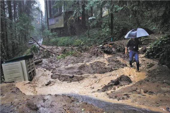  ?? Leah Millis / The Chronicle ?? Nathan Quarles of Sonoma County’s resource management agency inspects a mudslide on Santa Rosa Avenue that forced the red-tagging of two homes.