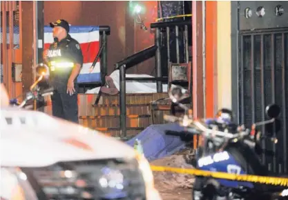  ?? RAFAEL MURILLO ?? Los cuerpos quedaron cerca de la entrada principal del bar en el cual laboraban los dos fallecidos. La Fuerza Pública custodió la escena hasta su levantamie­nto, la madrugada del sábado .