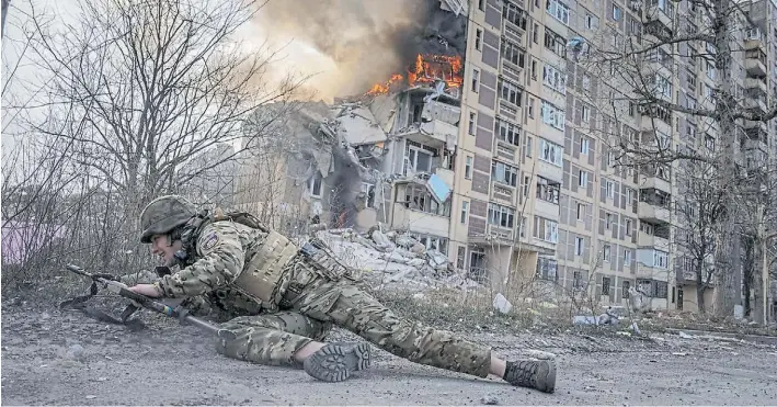  ?? AP ?? Fuego. Un soldado ucraniano busca protegerse durante un ataque ruso a la ciudad de Adviidka, tomada días atrás por las tropas del Kremlin. La guerra se prolonga en Ucrania.