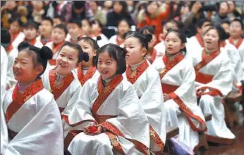  ?? SHAO DAN / FOR CHINA DAILY ?? Primary school children in Han-style robes take part in a traditiona­l ceremony on Wednesday in Nanjing, Jiangsu province, that was held in ancient times to mark the year a child enters puberty.