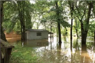  ?? Staff photo by Evan Lewis ?? The Little River is overflowin­g into yards at the Little River Club, which is a private club and community on the river near Winthrop, Ark., in Little River County. The river crested at 31.25 feet on Wednesday. Longtime residents have seen conditions a...