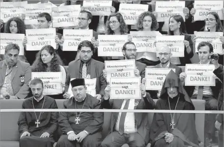  ?? Michael Sohn Associated Press ?? GUESTS hold placards thanking the German Parliament for voting to recognize the killings of Armenians a century ago as genocide.