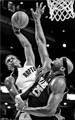  ?? STEVE RUSSELL/TORONTO STAR ?? Raptors forward Chris Bosh tries to get a shot away as Dallas centre Erick Dampier gets his hand in the way during the first half at the Air Canada Centre last night. Bosh finished the night with 26 points.