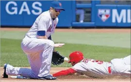  ?? Kathy Willens Associated Press ?? NEW YORK METS second baseman Neil Walker reacts as the throw bounces in front of him with the Angels’ Danny Espinosa sliding in on a stolen base.