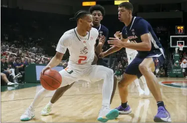  ?? AP PHOTO/MARTA LAVANDIER ?? Virginia guard Reece Beekman, center and forward Kadin Shedrick (21) defends Miami guard Isaiah Wong (2) during the first half of an NCAA college basketball game, Tuesday, Dec. 20, 2022, in Coral Gables, Fla.