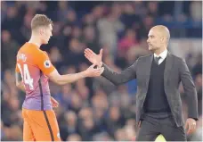  ?? — Reuters ?? Manchester City manager Pep Guardiola shakes hands with John Stones after the game.