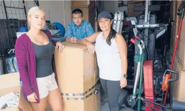  ?? MARTA LAVANDIER/AP ?? Wendy Kaufman stands in her packed garage April 12 with her daughter Jaedyn, 19, and son Julian, 14 in Doral, Fla. The Kaufmans moved from Germany and have been unable to find a home big enough that they can afford.