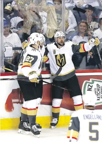  ?? JASON HALSTEAD/GETTY IMAGES ?? Tomas Tatar, right, celebrates his first-period goal with Vegas Golden Knights teammates Shea Theodore and Pierre-Edouard Bellemare on Monday during their 3-1 win over Winnipeg.