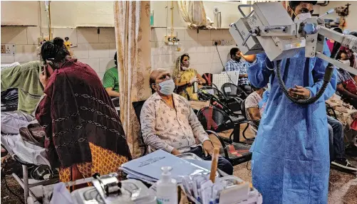  ?? | REUTERS ?? PATIENTS suffering from COVID-19 receive treatment in the emergency ward at Holy Family hospital in New Delhi, India. India is a high-risk setting for an epidemic, but its current situation was not inevitable, says the writer.