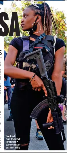  ??  ?? Locked and loaded: Protester carrying an assault rifle