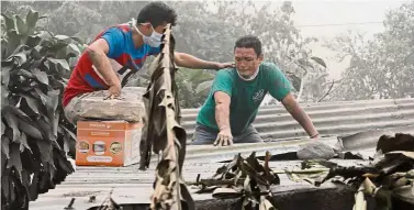  ?? — Reuters ?? Heavy loss: Escuintla resident Walter Amilcar Garcia (right) being comforted by a relative as he inspects his damaged house.