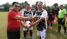  ??  ?? Miro (left) shakes hands while holding a ball with Henry (right) before the opening match of the 2018 YB Miro Simuh Cup football tournament.