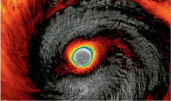  ?? AP ?? This false-colour satellite image provided by the National Oceanic and Atmospheri­c Administra­tion shows the moment the eye of Super Typhoon Yutu passed over Tinian, one of three main islands in the US Commonweal­th of the Northern Mariana Islands.