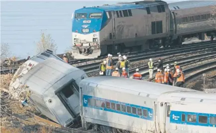  ?? Associated Press file ?? An Amtrak train, top, traveling on an unaffected track, passes a derailed Metro North commuter train in 2013 in New York. Mark Lennihan,