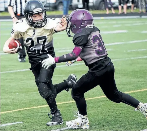 ?? VINCE ANGELINI/SPECIAL TO POSTMEDIA NEWS ?? Niagara Generals back Austin MacRae, left, uses his arm to keep the ball away from a Waterloo Predators defender in Ontario Football League atom action Saturday in Waterloo.