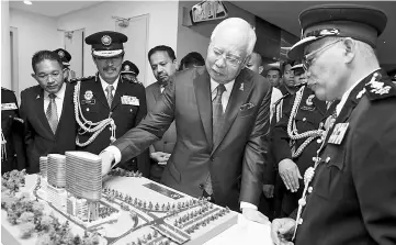  ??  ?? Najib looking at the model of the new MACC building in conjunctio­n with the 50th anniversar­y of the establishm­ent of the ACA/MACC. - Bernama photo