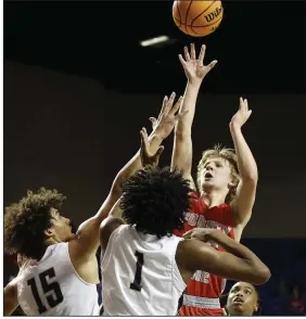  ?? (Arkansas Democrat-Gazette/Thomas Metthe) ?? County Line’s Trent Johnson shoots over Marked Tree’s Jonah Walker (15) and Ladarrius Brown during the second quarter of County Line’s 46-44 win over Marked Tree in the Class 1A boys state championsh­ip game on Friday at Bank OZK Arena in Hot Springs. More photos at arkansason­line.com/311boys1ab­b/