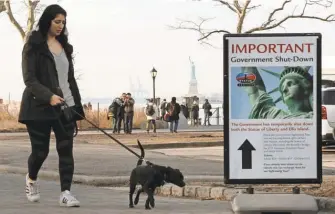  ?? EDUARDO MUNOZ ALVAREZ/ GETTY IMAGES ?? Would- be visitors to the Statue of Liberty could get no farther than the ferry terminal at Battery Park on Sunday as the iconic New York City landmark remained closed in the face of a government shutdown.