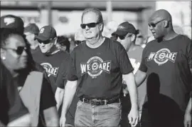  ?? Kirthmon F. Dozier Detroit Free Press ?? UAW PRESIDENT Gary Jones, center, marches with union members in a Labor Day parade in Detroit. He had vowed to win back the trust of the rank-and-file.