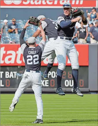  ?? BILL KOSTROUN/AP PHOTO ?? Jacoby Ellsbury (22) joins Aaron Judge, right, and Aaron Hicks for an outfield celebratio­n after the Yankees defeated the Seattle Mariners 10-1 on Sunday at Yankee Stadium.