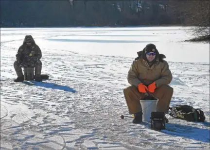  ?? PETE BANNAN — DIGITAL FIRST MEDIA ?? John and Matthew Young ice fish at Marsh Creek State Park Tuesday.