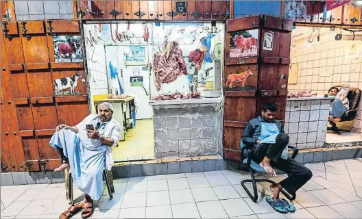  ?? GIUSEPPE CACACE / AFP ?? Color local. Carniceros en el zoco de Mubarakia, en la capital kuwaití. Abajo,el emir de Kuwait, Sabah el Ahmad al Sabah